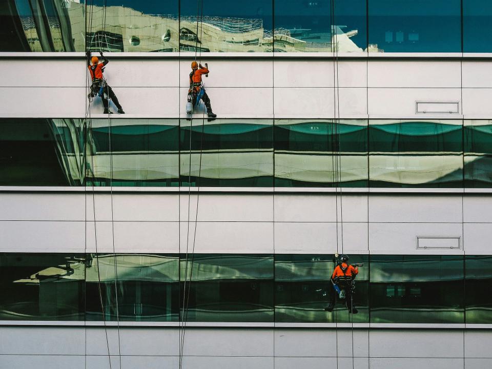 Personas limpiando una fachada